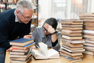 woman in the library in front of bookshelves. Concept of education