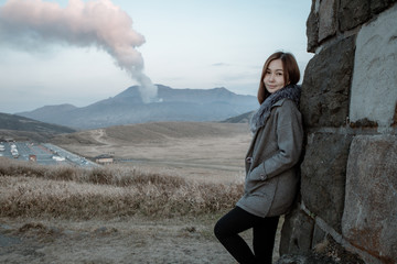 Lonely girl in Area of Aso active volcano background with smoke at Mount Aso Nakadake, Kumamoto, kyushu, Japan. (Photo grain some noise on film colour)