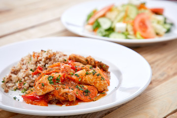 meat with buckwheat and salad on the wooden background