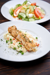 chicken kebab with rice and vegetables on the wooden background