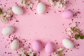 Easter eggs with branch of apple blossom on pink background