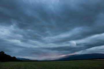 Obraz na płótnie Canvas Tarras New Zealand coast. Thunder and rain clouds at twilight