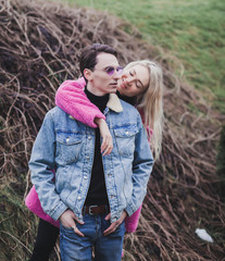 Fototapeta premium young couple in love outdoor. Stunning portrait of young stylish fashion couple posing in field