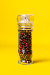 Pepper mill on yellow background
