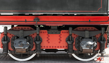 Wheels of a steam locomotive with red and black