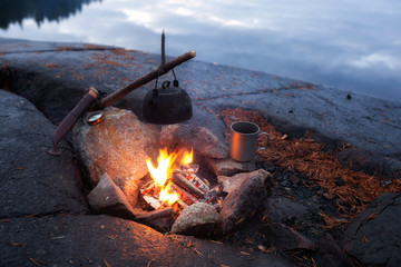 Black coffee pot on campfire closeup. Camp concept.
