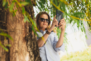 Woman with sunglasses taking photo with phone
