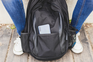 Close-up shot of woman placing phone in purse pocket