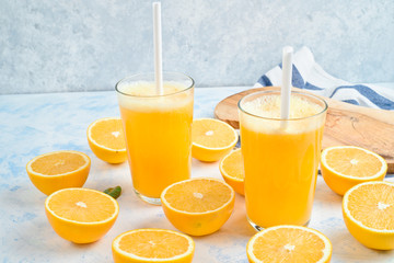 fresh orange Juice and oranges on the cutting board