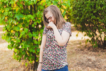 Shy woman with eyeglasses looking down outside