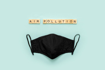 Black pm2.5 mask on blue background. Top view. Ait pollution problem. Ecology