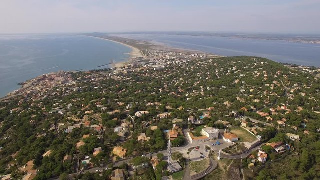 Aerial shot above Mont Saint Clair, at the top of Sete, south of France. Nice view on the beach, mediterranean sea and That pond.