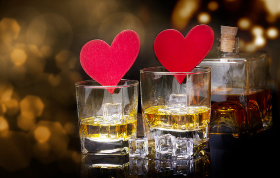 Whiskey and hearts against bokeh, clinking glasses for Valentine's Day