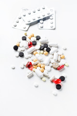 Different shapes and colors of pills on a white background. Medical health concept.