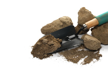 Dirt, soil pile and chunks with gardening trowel, shovel for planting isolated on white background