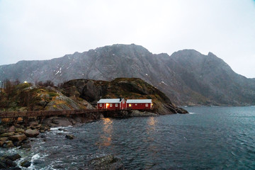 Old red fisherman's house on a cliff. Lofoten islands, Norway.