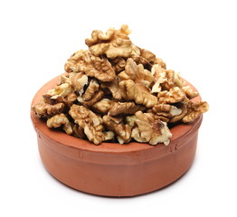 Unshelled walnuts in clay bowl isolated on white background