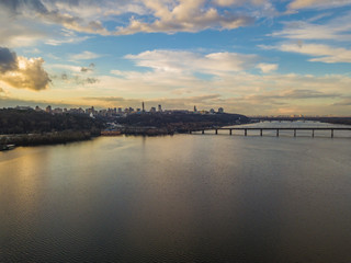 Aerial drone view. View of the Dnieper and the right bank of Kiev in the sunset. The sky is reflected in the water.