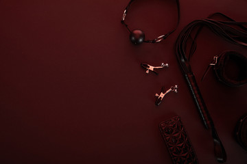 top view of sex toys in dark lighting on red background