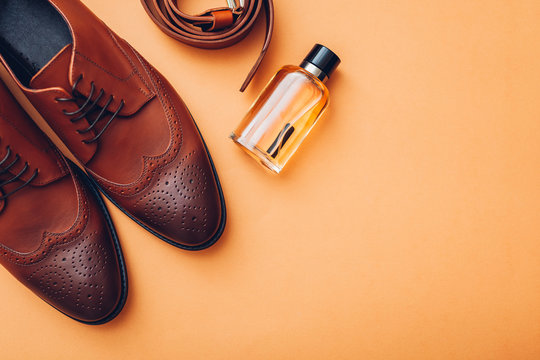Oxford male brogues shoes with accessories. Men's fashion. Classical brown leather footwear with belt and perfume.