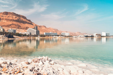 Dead sea salt shore. Salt on background of the sea and the coastal resort town Ein Bokek, Israel