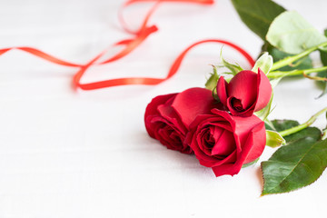 Beautiful red roses with red ribbon on white background. Perfect gift for Saint Valentines day, anniversary o birthday .