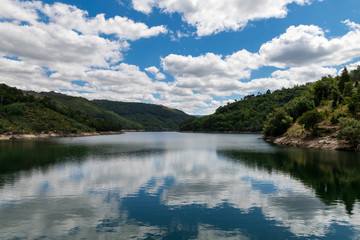 Beautiful tranquil view of a lake with the reflection of the clouds on the water at the Peneda Geres National Park, in Portugal, Europe