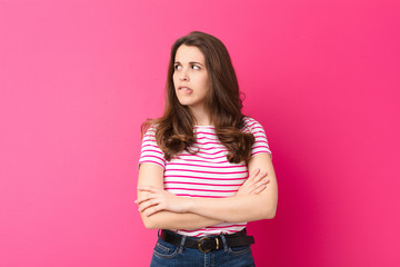 young pretty woman doubting or thinking, biting lip and feeling insecure and nervous, looking to...