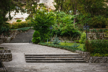 Tiled road in the Park. Grey tiles, steps, green Park in Bulgaria