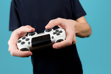 white modified joystick without identification marks from a game console in the hands of a teenager.