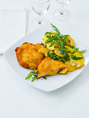 Hühnchen Cordon Bleu mit Kartoffelsalat auf weißem Hintergrund