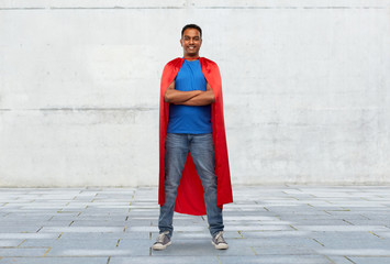 super power and people concept - happy smiling indian man in red superhero cape with arms crossed...