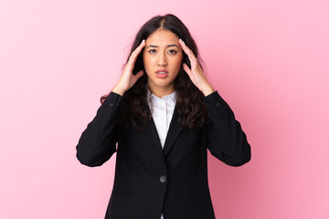 Mixed race business woman over isolated pink background unhappy and frustrated with something. Negative facial expression