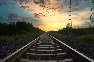 Zelfklevend Fotobehang Lange spoorlijn die leidt naar een prachtige zonsondergang. © Eeli Purola