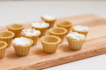 Tartlets with custard or cottage cheese. Empty tartlets or pie on a white table. Food lay flat. The view from the top. The concept of preparing food for the holiday table.