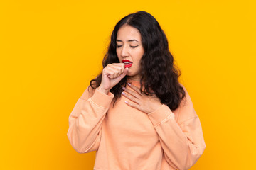 Spanish Chinese woman over isolated yellow background is suffering with cough and feeling bad