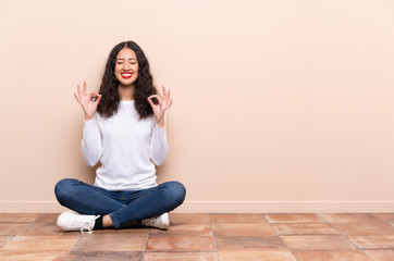 Young woman sitting on the floor in zen pose