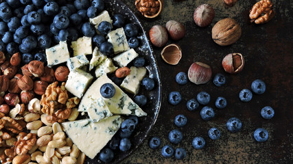 Plate with cheese, nuts and blueberries. Healthy snack. Keto diet.