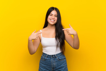 Young teenager Asian girl over isolated yellow background proud and self-satisfied