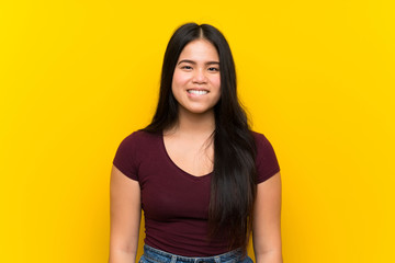 Obraz premium Young teenager Asian girl over isolated yellow background having doubts and with confuse face expression