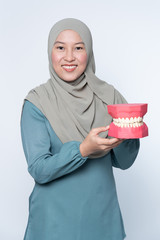 Muslim female holding a teeth mould - dentistry concept