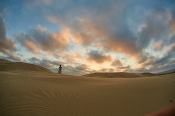 Fototapeta na wymiar Lighthouse on beach in sunset
