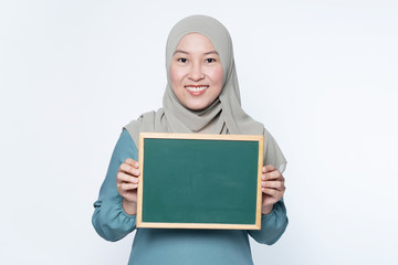 Female muslim woman holding a chalk board.