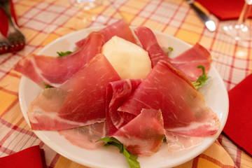 Delicious bacon arugula salad with mozzarella. Salad with parma ham (jamon), tomatoes and Cheese.
