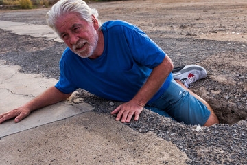 one senior or pensioner falled in the groud because he put a foot in a hole in the street - mature...