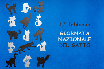 Happy Cat Day in Italy. Border made of black and grey funny cat silhouettes on blue background. Festive layout for feline holiday, text in Italian 17 FEBRUARY NATIONAL CAT DAY. Flat lay, top view