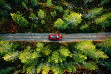 Fotobehang Aerial view of red car with a roof rack on a country road in Finland © nblxer