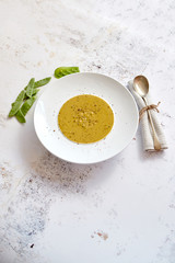 Creamy soup with green pea in a ceramic white plate