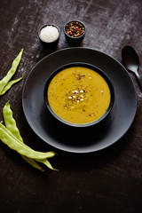 Creamy soup with green pea in a ceramic white plate