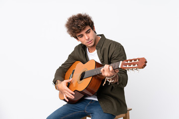 Obraz premium Young caucasian man with guitar over isolated white background